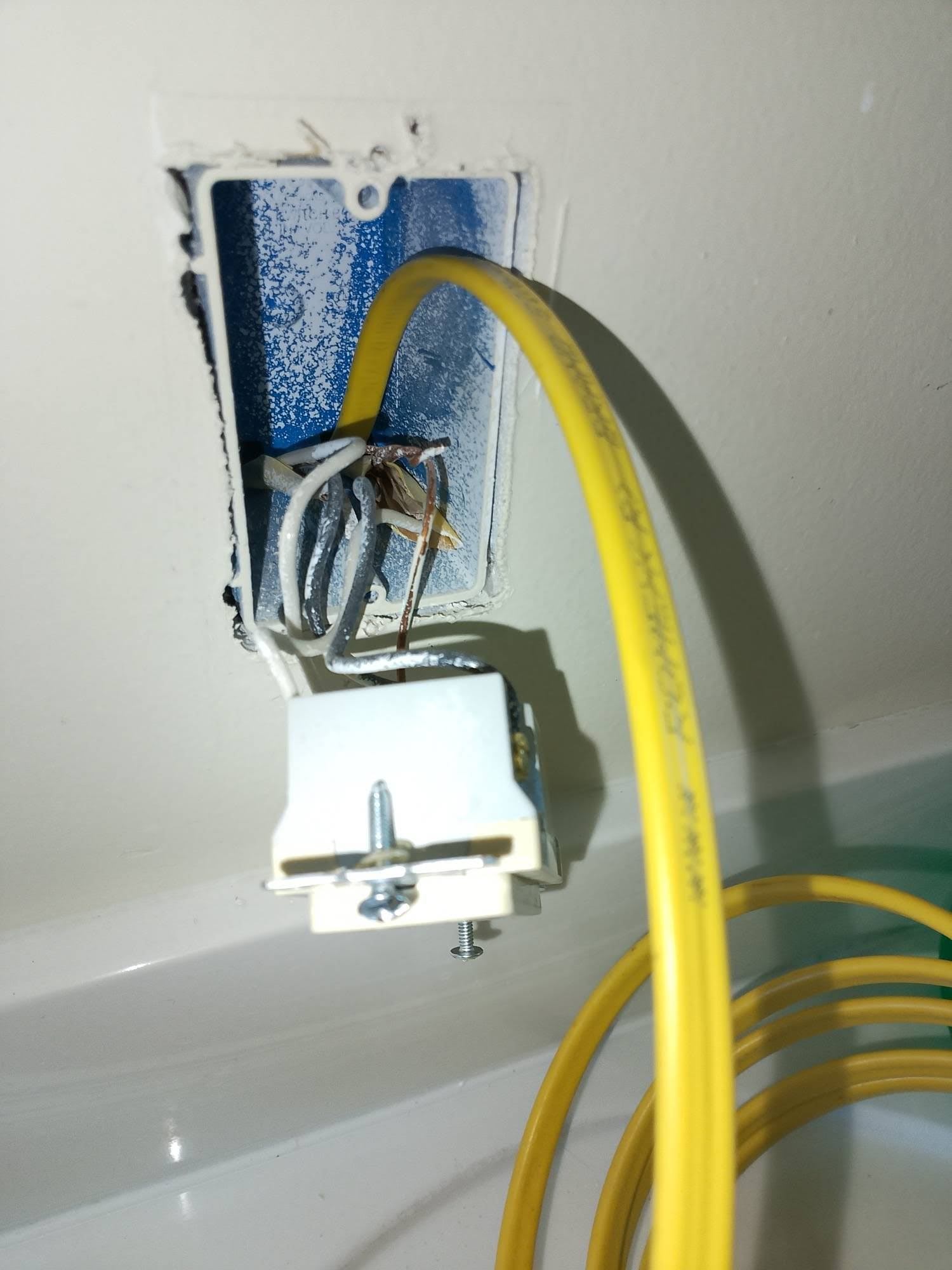 Yellow electrical Romex wire pulled through the open GFCI electrical box